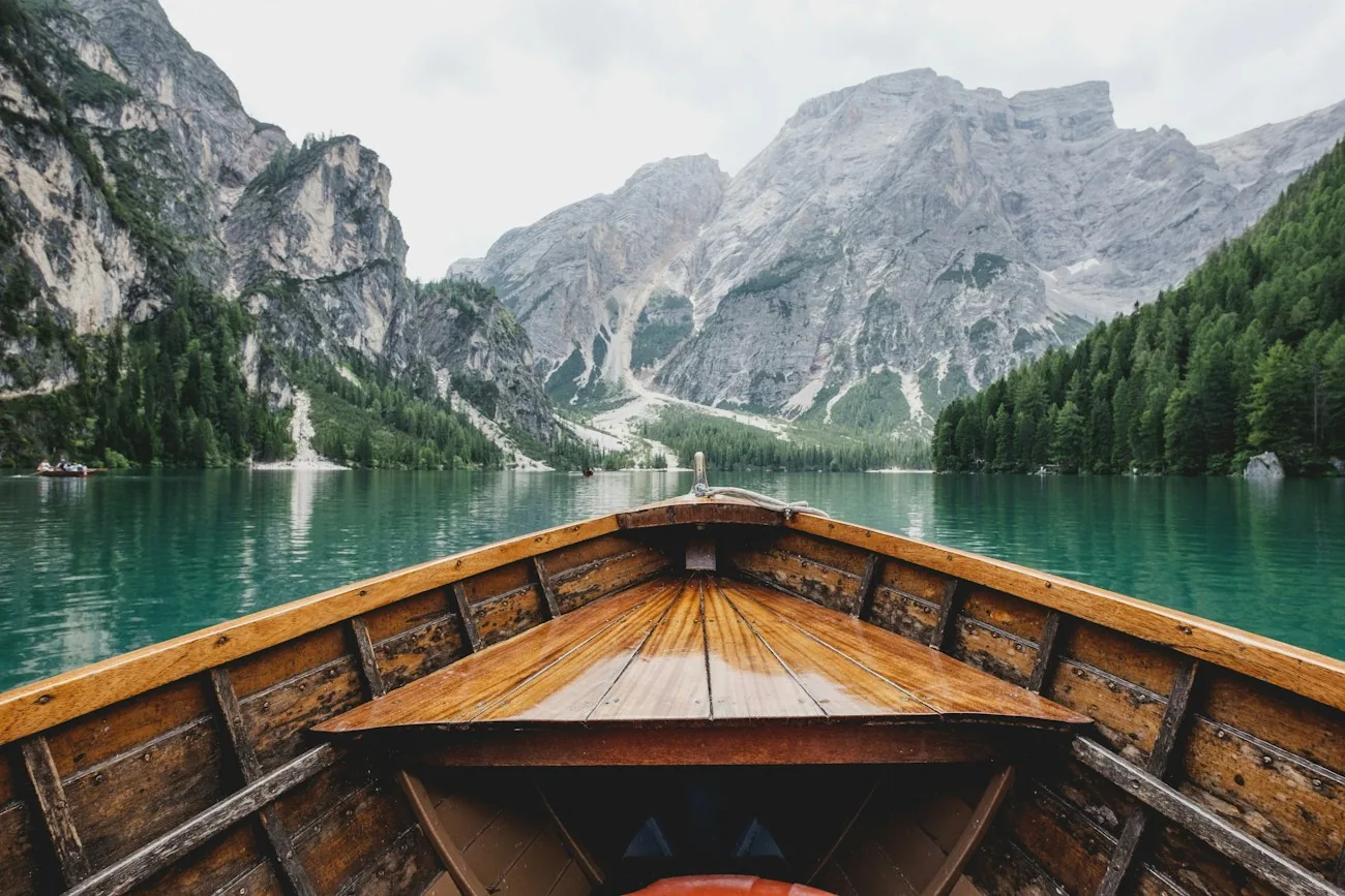 Um barco de madeira em um lago cercado por montanhas